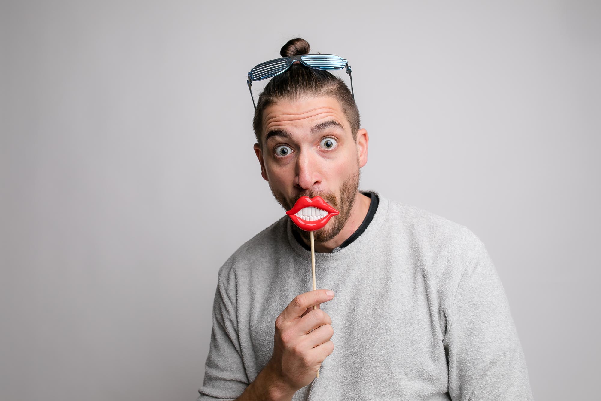 Zwei Freunde mit aufblasbaren Gitarren und Rock-Perücken posieren vor der Fotobox.