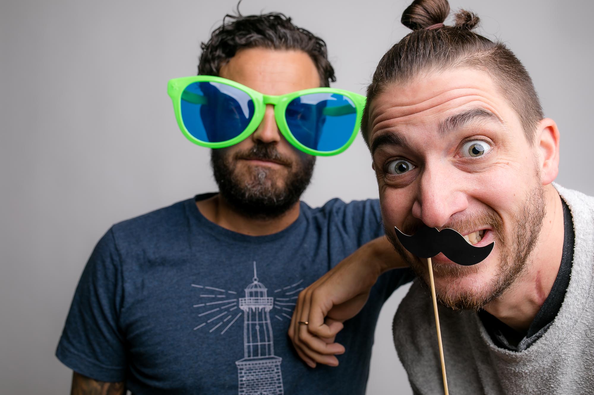 Eine Person mit Clownsnase und großer Partybrille macht eine Grimasse vor der Fotobox.