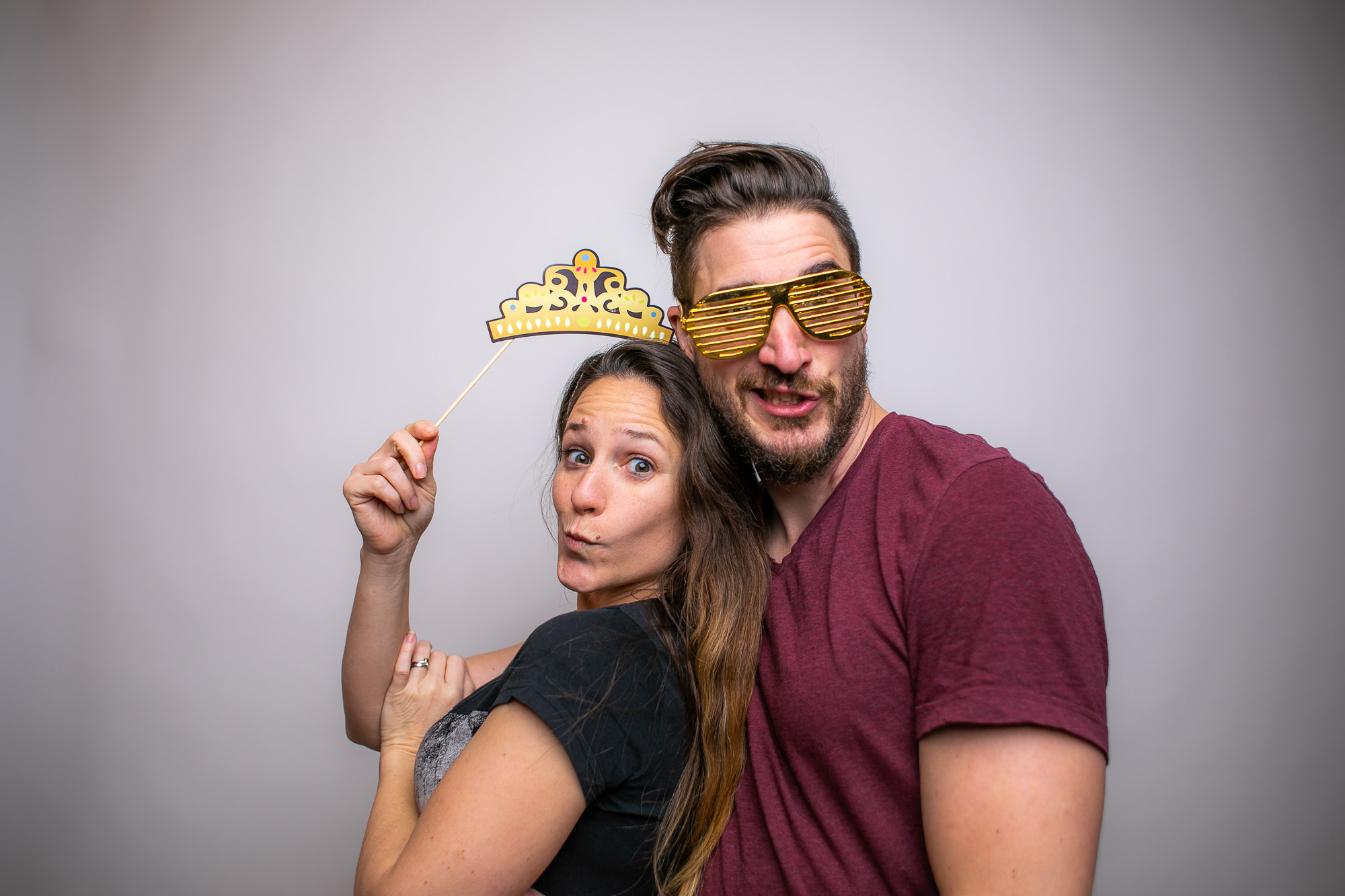 Zwei Gäste mit Superheldenmasken und Umhängen posieren vor der Fotobox.